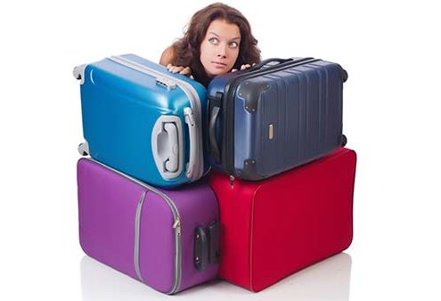 En kvinde gemmer sig bag en masse tung bagage