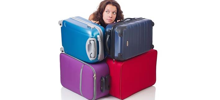 En kvinde gemmer sig bag en masse tung bagage